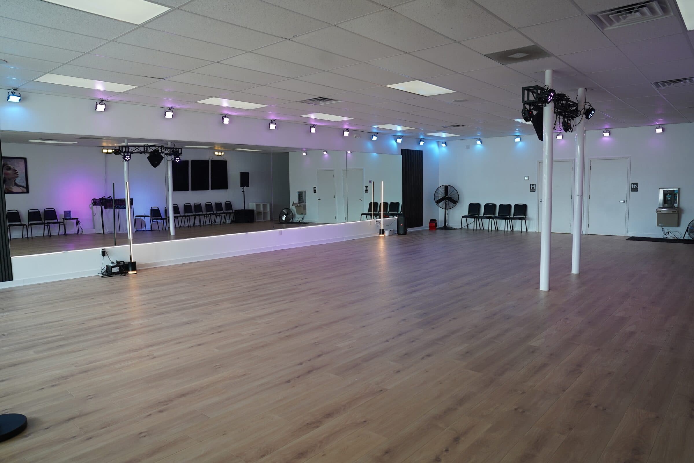 Wide view of the hardwood dance floor under purple and blue accent lights