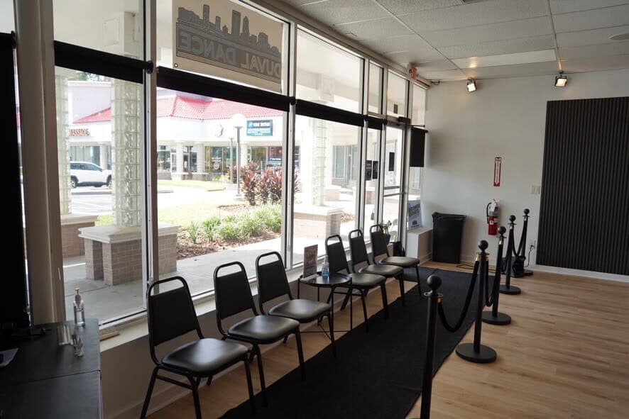 Waiting area by the front windows with chairs and rope stanchions